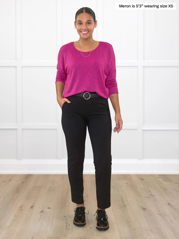 MIik model Meron (5'3", xsmall) smiling wearing Miik's Rosalie long sleeve dolman sweater in lipstick pink and dress pant and belt in black
#color_lipstick