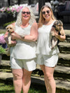 Miik models Colleen and Christal smiling both holding a puppy and wearing Miik's Sarit short PJ lounge set in grey stripe  #color_grey-natural-stripe