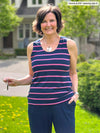 Miik founder Donna (5'6", small) smiling wearing Miik's Shandra reversible tank top - beach house stripe with a navy pant