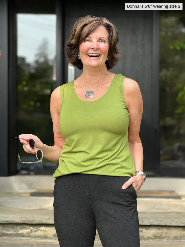 Miik founder Donna (5'6", small) smiling wearing Miik's Shandra reversible tank top in moss green with a charcoal pant 
#color_moss 