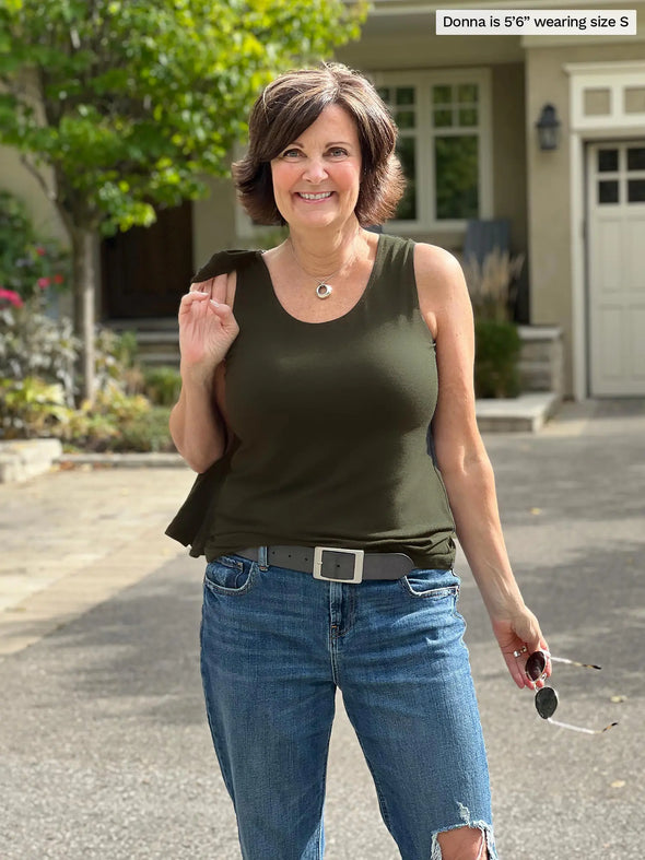 Miik founder Donna (5'6", small) smiling wearing Miik's Shandra reversible tank top in olive with a ripped jeans and  belt 
#color_olive 