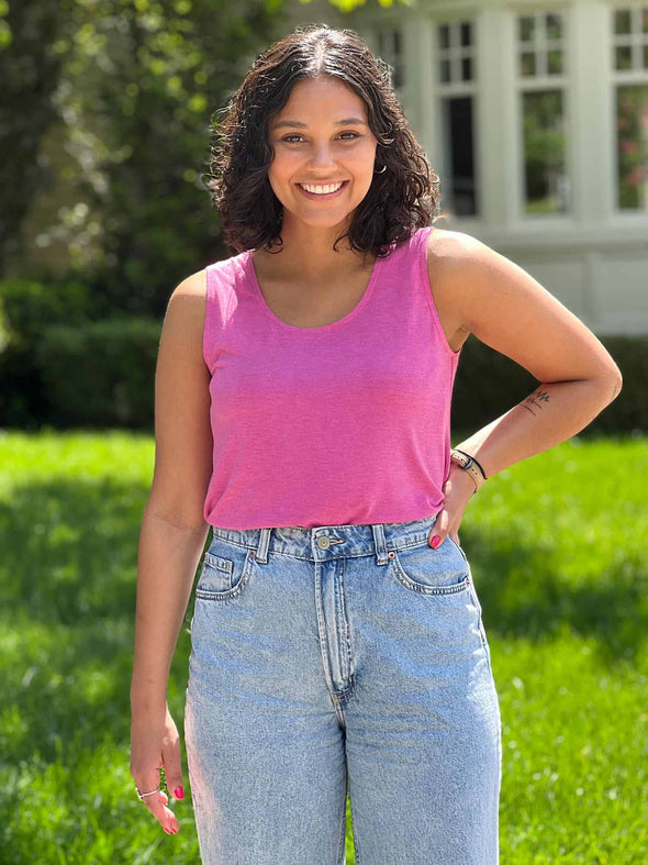 Miik model Meron (5'3", xsmall) smiling wearing Miik's Shandra reversible tank top in pretty in pink with jeans