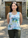 Miik model Yasmine (5'0", xsmall, petite) smiling and looking away wearing Miik's Shandra reversible tank top in water lily in the petite fit along with a dress pant in olive green 
#color_water-lily