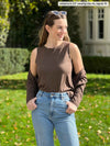 Miik model Johanna (5'6", xsmall) smiling and looking away wearing Miik's Shandra reversible tank top in chocolate melange along with jeans and a cardigan in the same colour of the tank
#color_chocolate-melange 