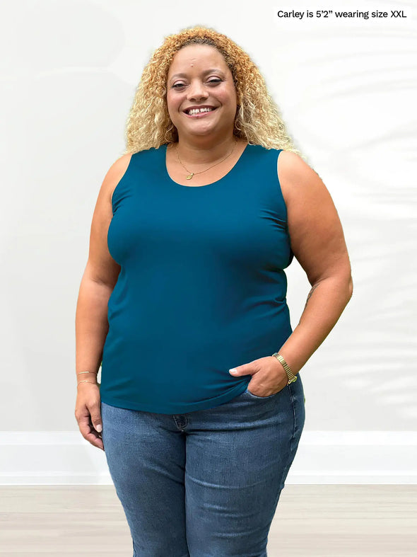 Miik model Carley (5'2", xxlarge) smiling wearing Miik's Shandra reversible tank top in teal with jeans 
#color_teal