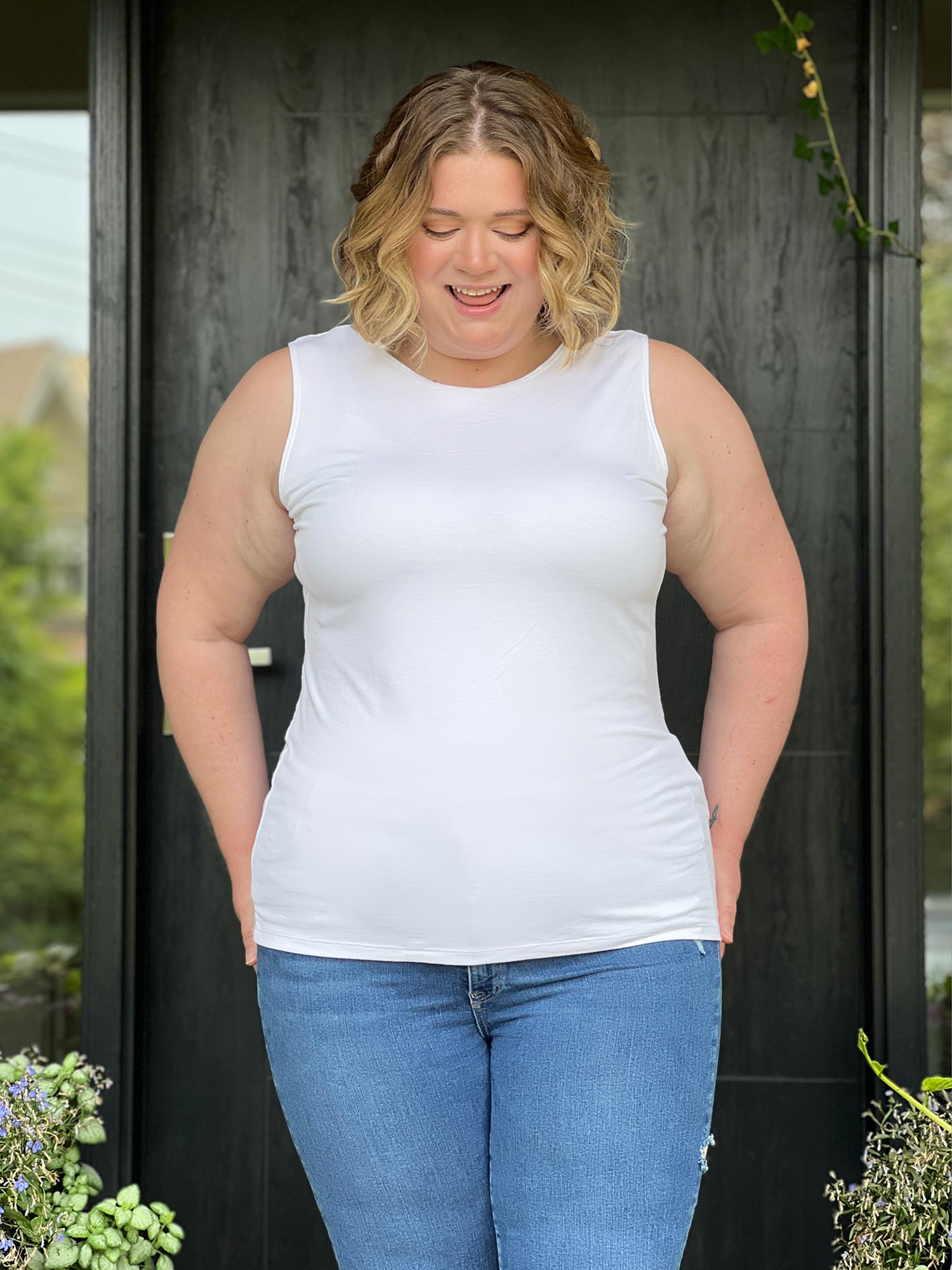 Miik model Bri (size XL, five foot five) wearing Shandra reversible tank top in white, reversed with the high neck in front.
