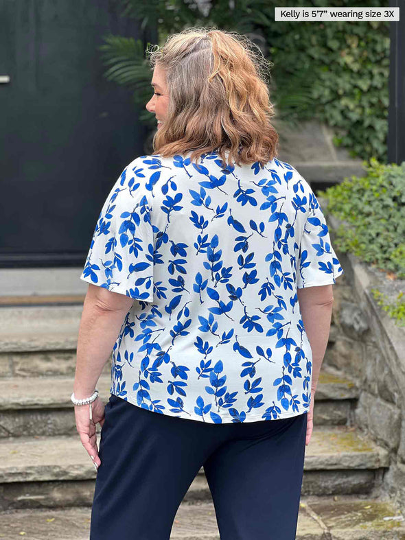 Miik model plus size Kelly (5’7”, 3x) standing with her back towards the camera showing the back of Miik's Shanice flutter sleeve square neck t-shirt