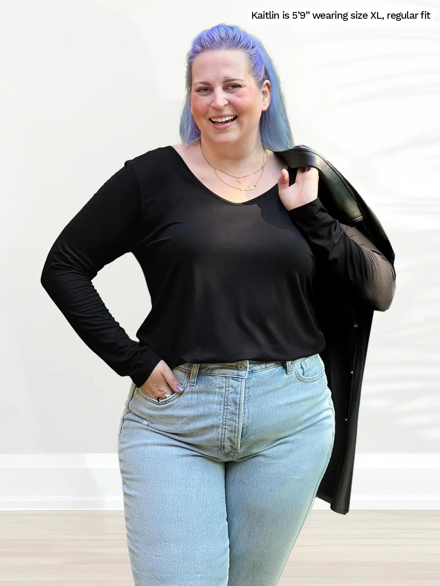 Miik model Kaitlin (size XL) wearing the Shannon long sleeve tee in black with jeans. 