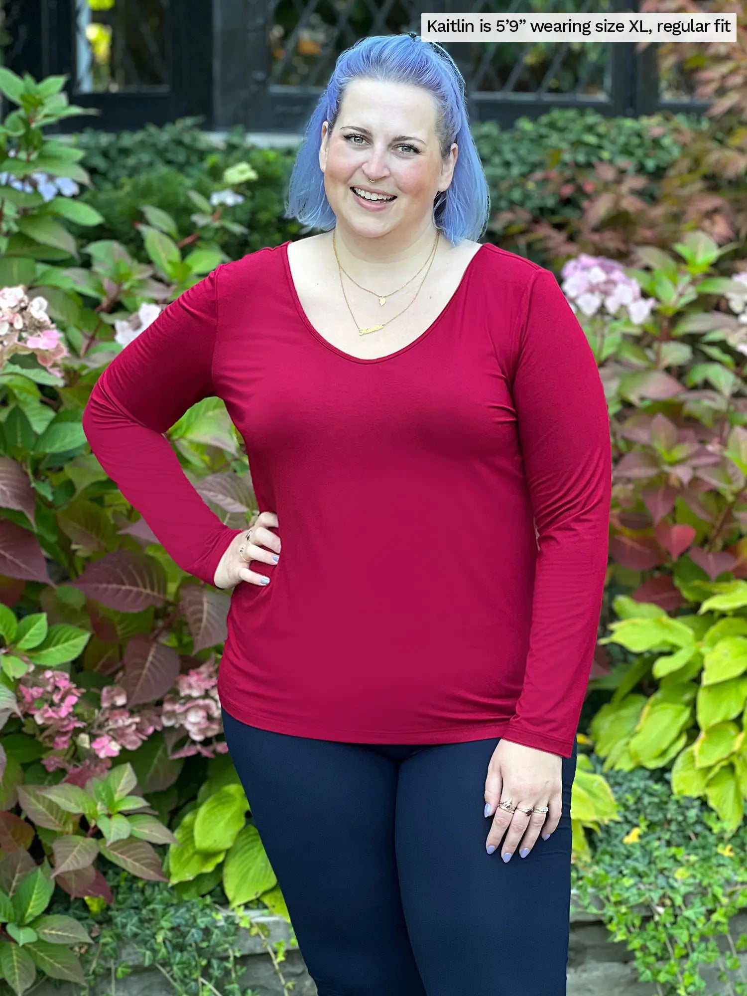 Miik model Kaitlin (size XL) wearing the Shannon reversible long sleeve tee in bordeaux red with navy pants. 