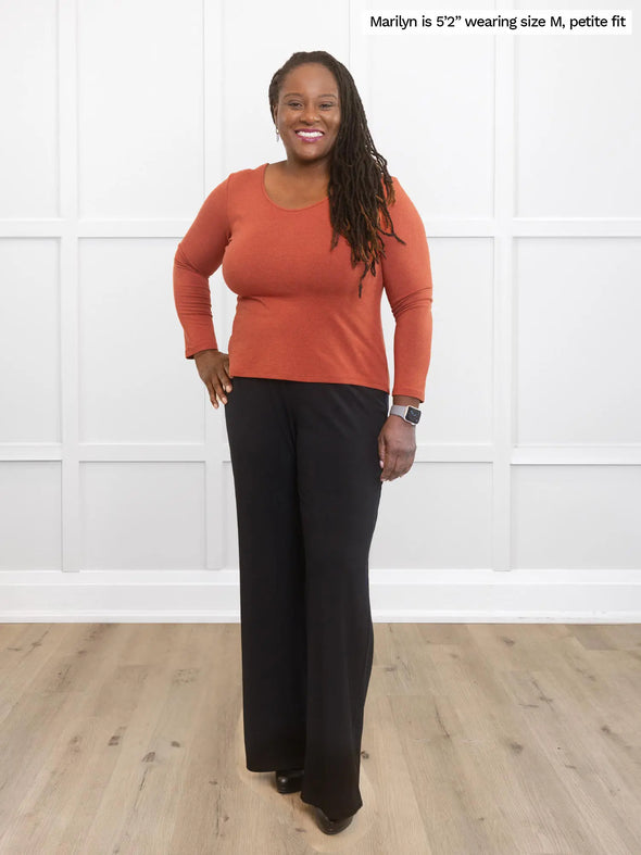 Miik model Marilyn (size M) wearing the Shannon reversible long sleeve tee in paprika orange, petite fit, with wide leg black trousers. #color_paprika-melange