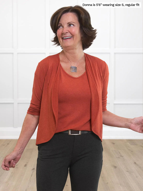 Miik founder Donna (size S) wearinf the Shannon long sleeve t-shirt in paprika orange under a matching waterfall cardigan with charcoal pants. #color_paprika-melange