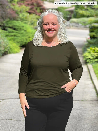 Miik model Colleen is wearing the Shannon reversible long sleeve tee in the petite fit in olive green with black pants. 