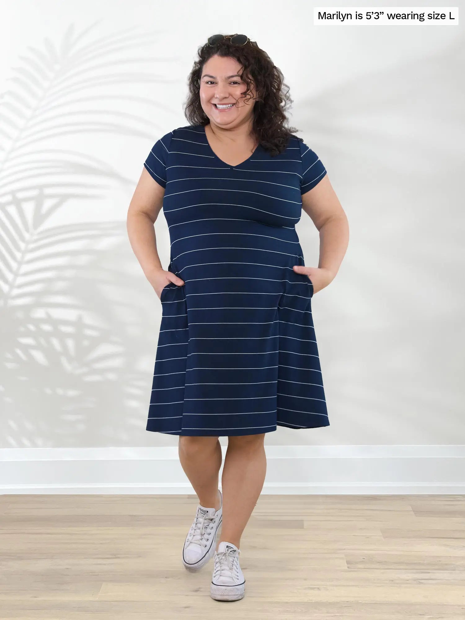 Miik model Marilyn (53&quot;, large) smiling with both hands on pockets wearing Miik&