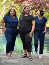 Miik models plus size Kimesha and Sureka along with founder Donna smiling all wearing Miik's Stef v-neck open-back capri jumpsuit