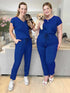 Miik models Jo and Bri standing next to each other both holding a puppy and wearing the same jumpsuit: Miik&