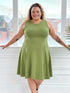 Miik model Carley (five feet two, size double extra large) smiling and standing in front of a window wearing Miik&