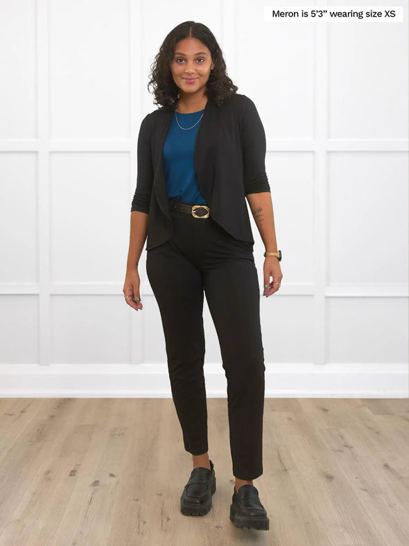 Miik model Meron (5'3", xsmall) smiling wearing a dress pant in black with Miik's Wesley cropped cardigan in the same colour along with a teal tank top
#color_black 