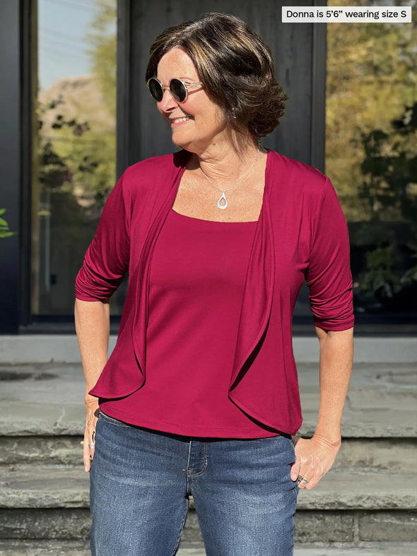 Miik founder Donna (5'6", small) smiling and looking away wearing Miik's Wesley cropped cardigan in cerise with a same colour tank and jeans 
#color_cerise 