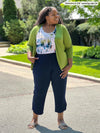 Miik model plus size Kimesha (5'8", 3x) smiling and looking away wearing Miik's Wesley cropped cardigan in green moss along with a printed tank top in water lily and a capri pant in navy 
#color_moss