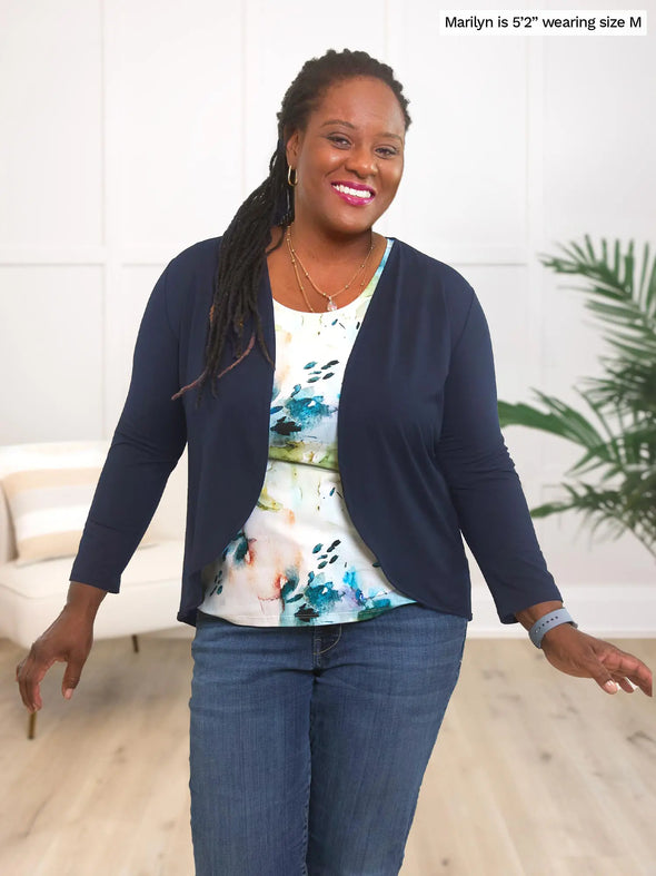 Miik model Marilyn (5'2", medium) smiling wearing a printed tank in water lily, along with jeans and Miik's Wesley cropped cardigan in navy
#color_navy