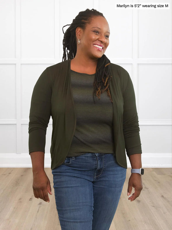 Miik model Marilyn (5'2", medium) smiling and looking away wearing Miik's Wesley cropped cardigan in olive with a striped 3/4 top with jeans 
#color_olive 