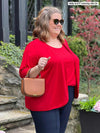Miik model plus size Kelly 95'7", 3x) smiling wearing Miik's Wesley cropped cardigan in poppy red with a matching colour tank top and a dress pant in navy