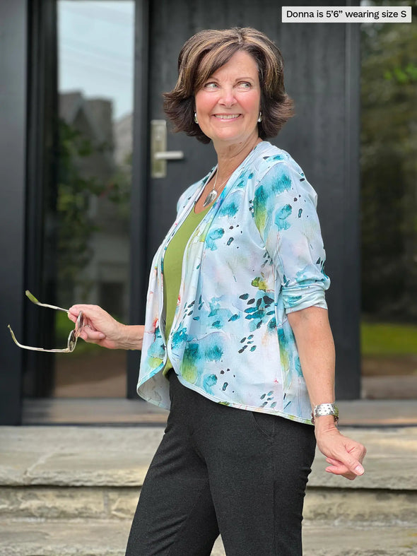 Miik founder Donna (5'6", small) standing sideway wearing Miik's Wesley cropped cardigan in water lily print with a green moss tank and charcoal dress pant 
#color_water-lily