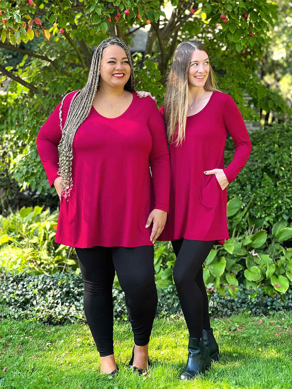 Miik models Sarita and Jo standing next to each other looking away both wearing the same outfit: Miik's Zuri long sleeve pocket tunic in bordeaux and black leggings #color_bordeaux