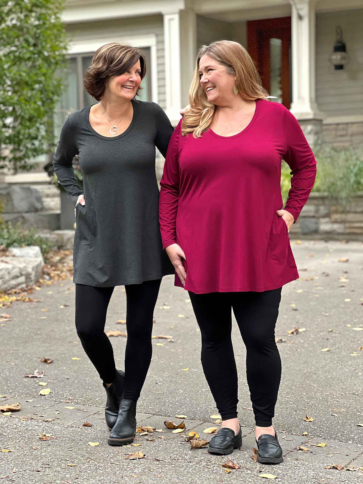 Miik founder Donna and model Kelly smiling while looking at each other both wearing the same outfit but in different colours. They are both wearing high waited legging in black with Miik&