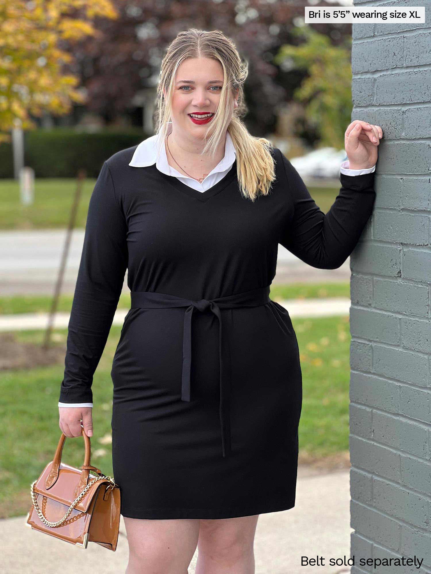 Woman smiling standing next to a brick wall wearing Miik&