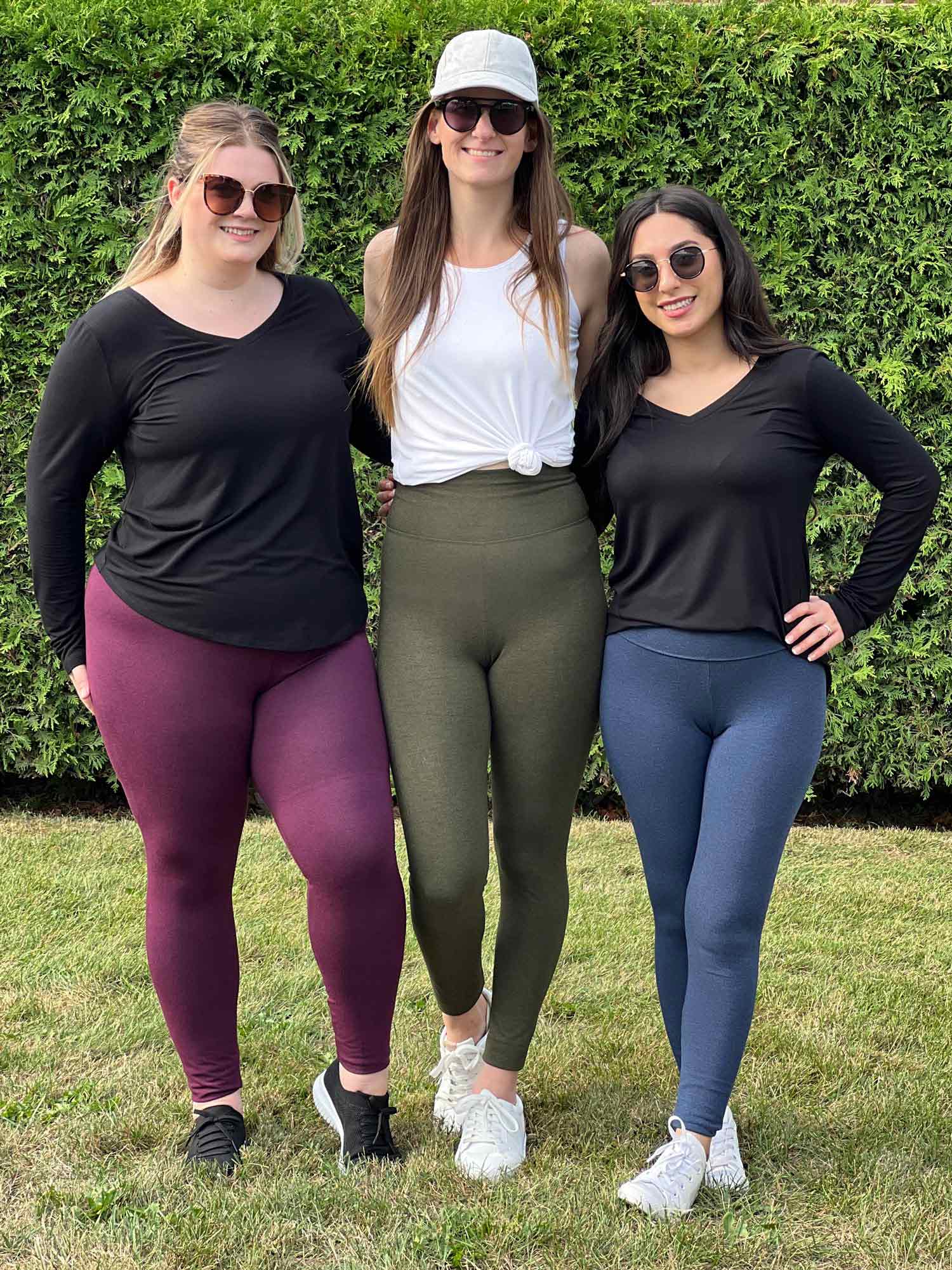 Three women smiling standing on grass wearing Miik&