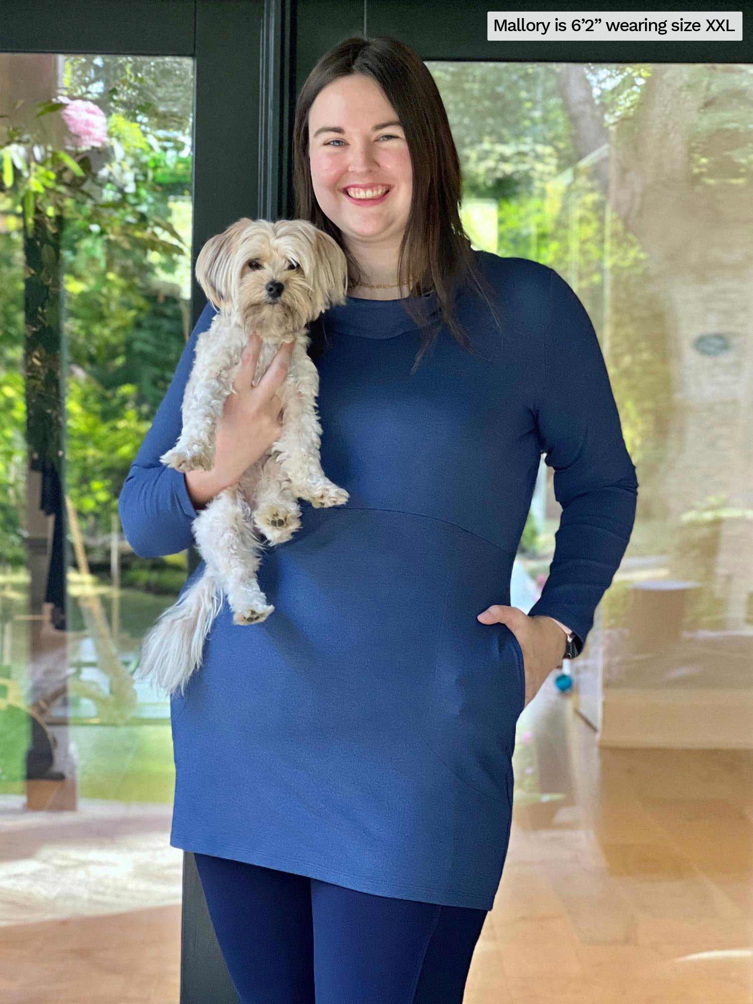 Woman smiling and holding a dog wearing a navy legging along with Miik&